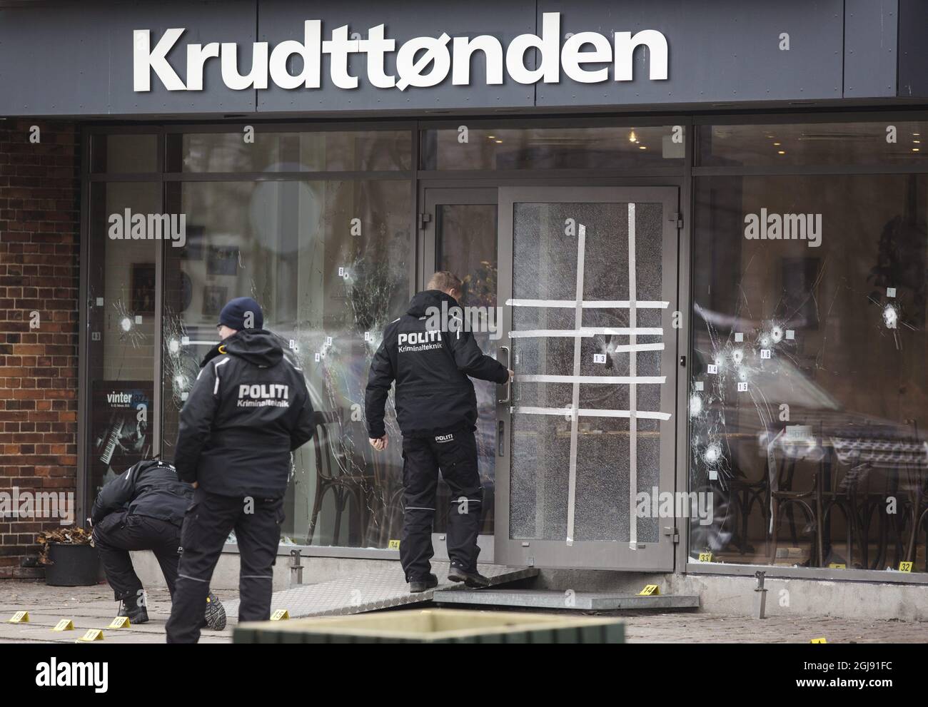 COPENHAGEN 2015-02-15 Police investigators work outside the entrance filled with bullet holes at the KrudttÃ¸nden culture club in Copenhagen, Denmark, February 15, 2015. The Danish police shot and killed a suspected terrorist early Sunday morning. The man killed is suspected of the attacks against the main synagogue and a debate on Islam and free speech with Swedish cartoonist Lars Vilks at the KrudttÃ¸nden culture club. Photo: Ola Torkelsson / TT / Kod 75777 ** SWEDEN OUT **  Stock Photo
