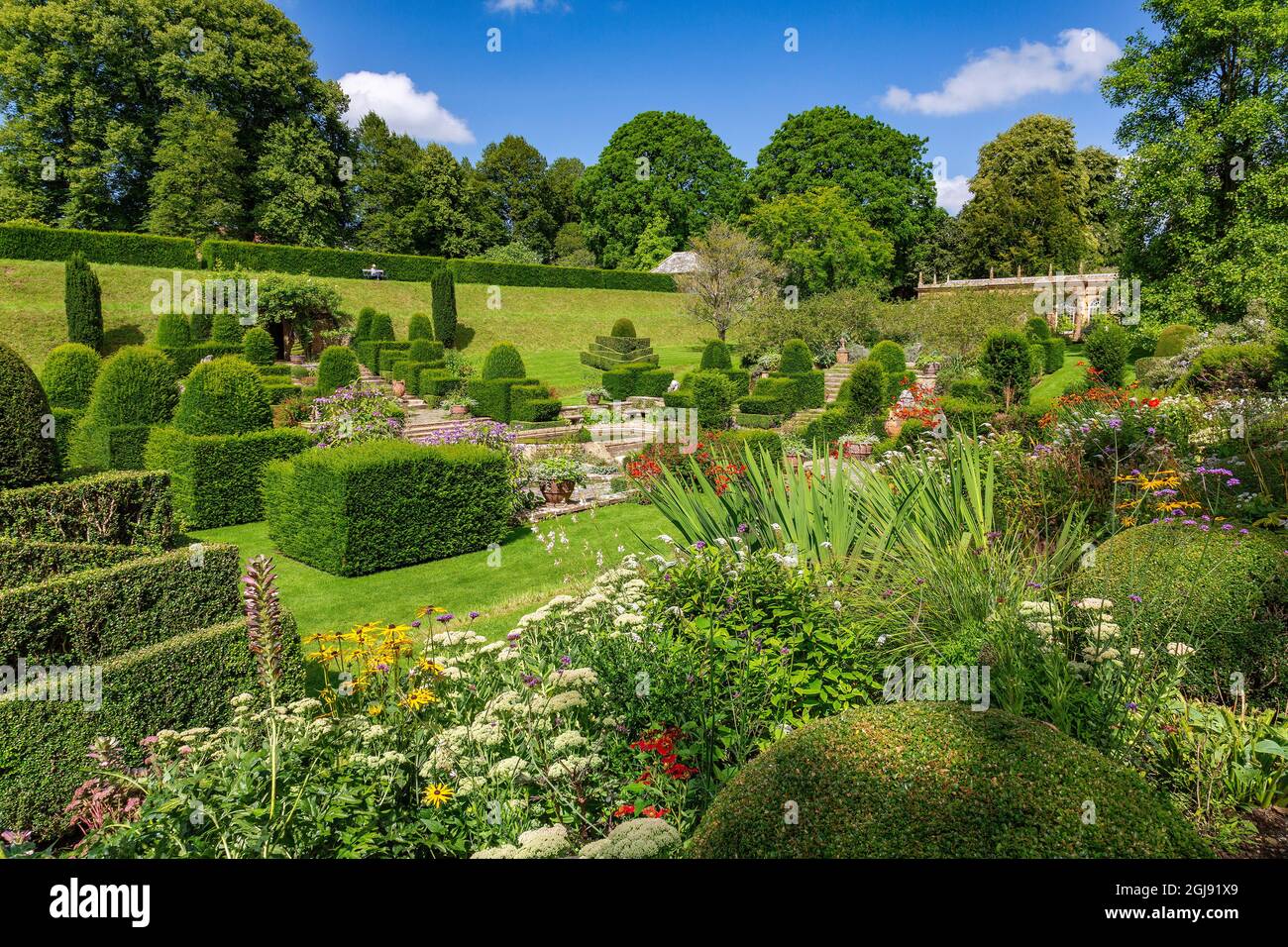 The colourful borders and topiary in the italianate Fountain Court garden at Mapperton House, Dorset, England, UK Stock Photo