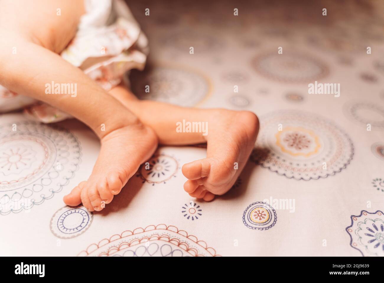 Closeup of unrecognizable cute baby shaking feet while lying in bed