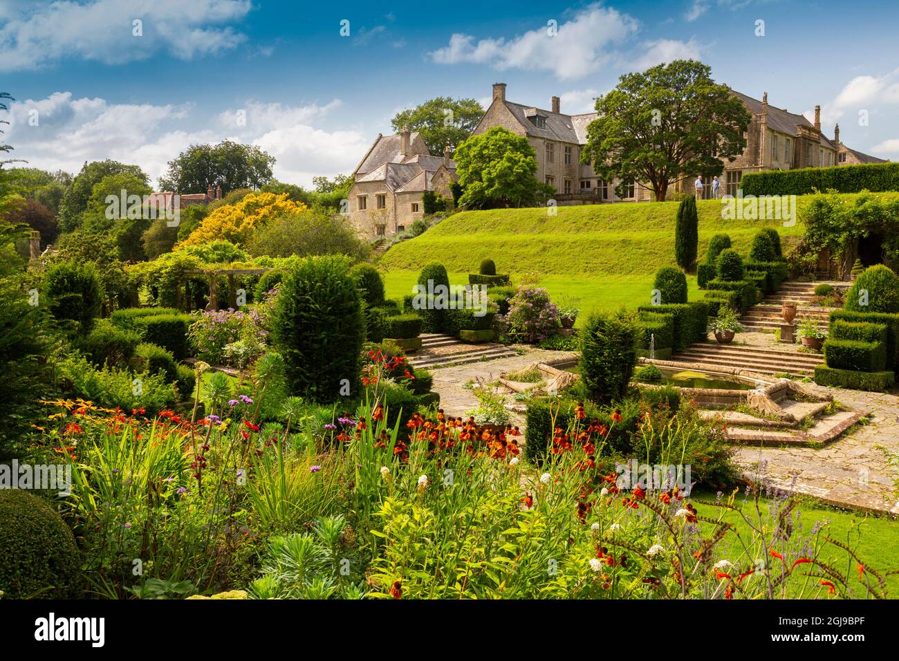 The colourful borders and topiary in the italianate Fountain Court garden at Mapperton House, Dorset, England, UK Stock Photo