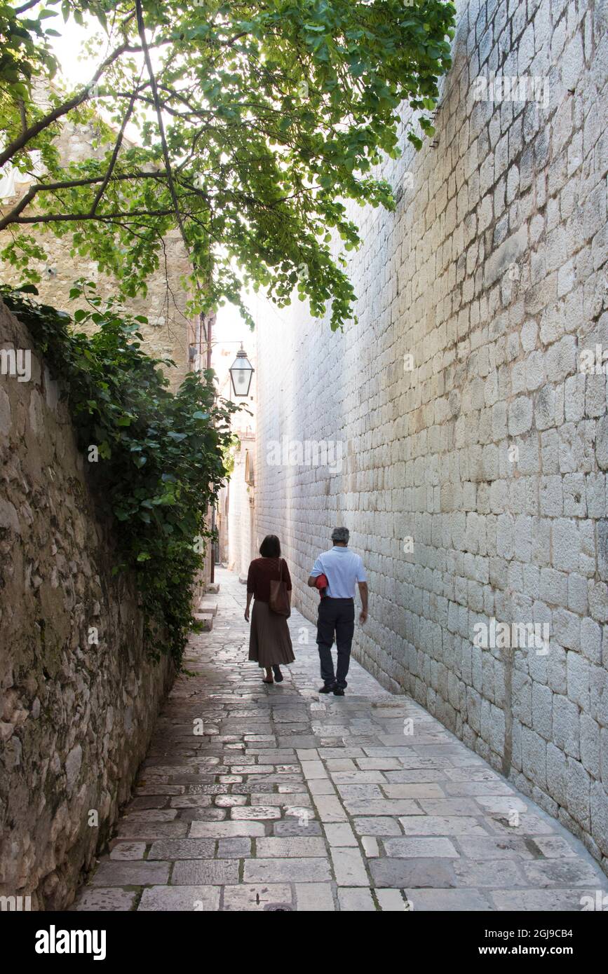 Croatia, Dubrovnik. Walled old city. Couple walks uncrowded stone lane ...