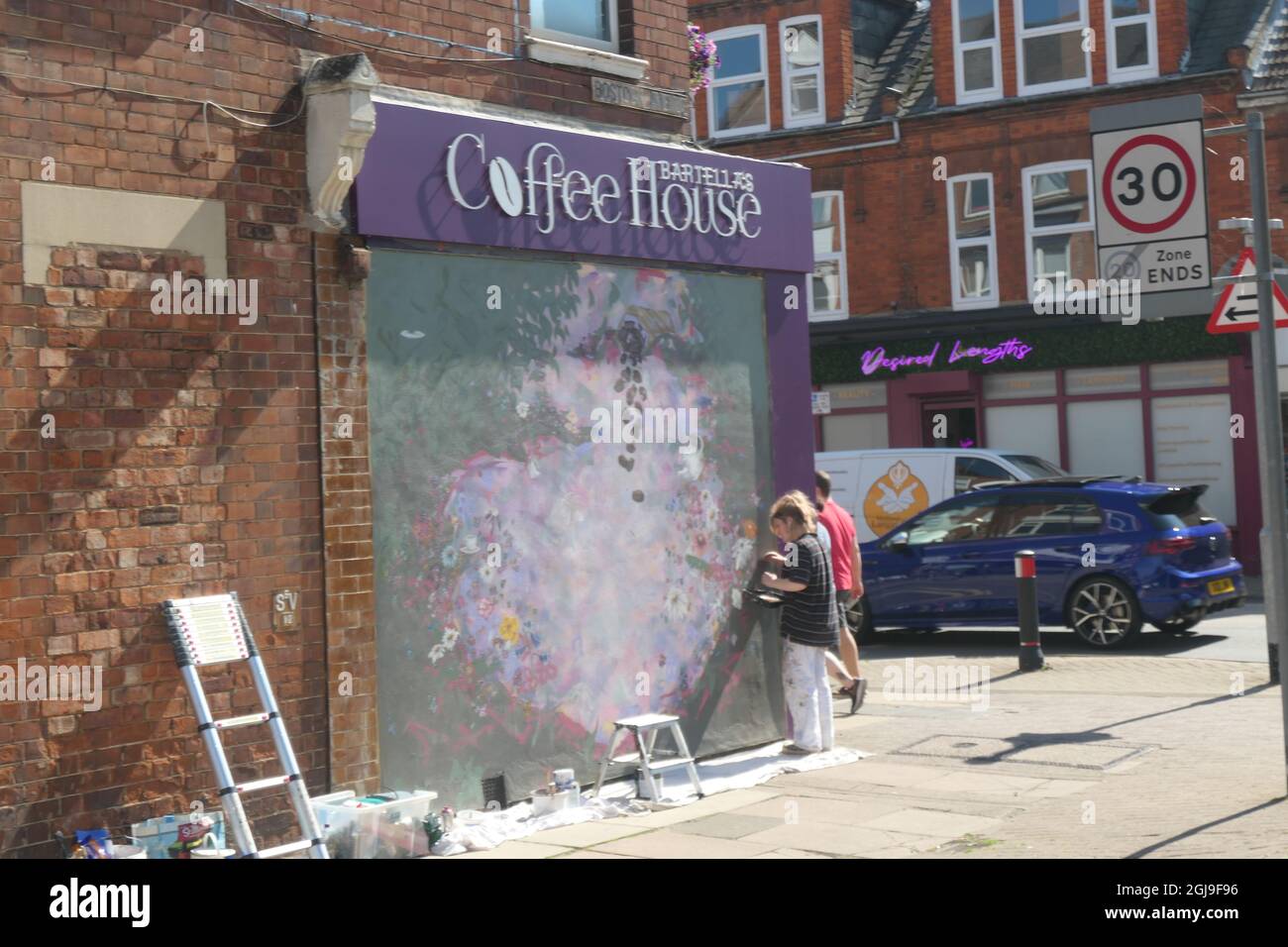 Wall painter artist at Coffee shop Northampton UK painter girl paint