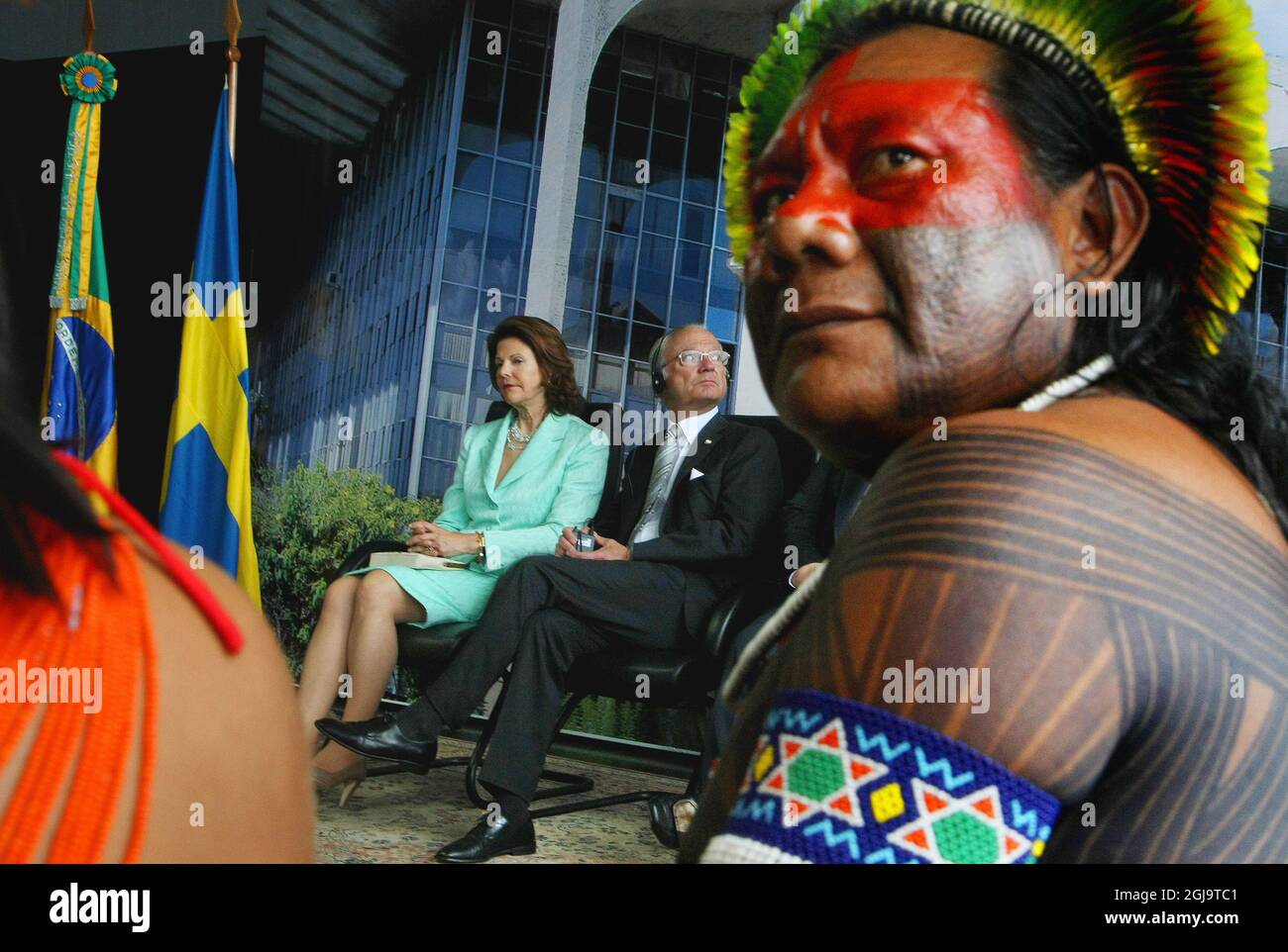 King Carl XVI Gustaf (C) and Queen Silvia hold a meeting with a Brazilian indigenous chief, at the Justice Palace in Brasilia, on March 24, 2010. King Carl XVI Gustaf and Queen Silvia arrived in Brazil Tuesday for a visit scheduled ahead of a Brazilian decision on a fighter jet tender that has a Swedish plane in the running. The royal couple was accompanied by Swedish Defense Minister Sten Tolgfors and several Swedish business leaders. Swedish company Saab is competing in the Brazilian jet tender with its Gripen NG mono-motor fighter. AFP PHOTO/Adriano Machado Swedish King Carl XVI Gustaf will Stock Photo