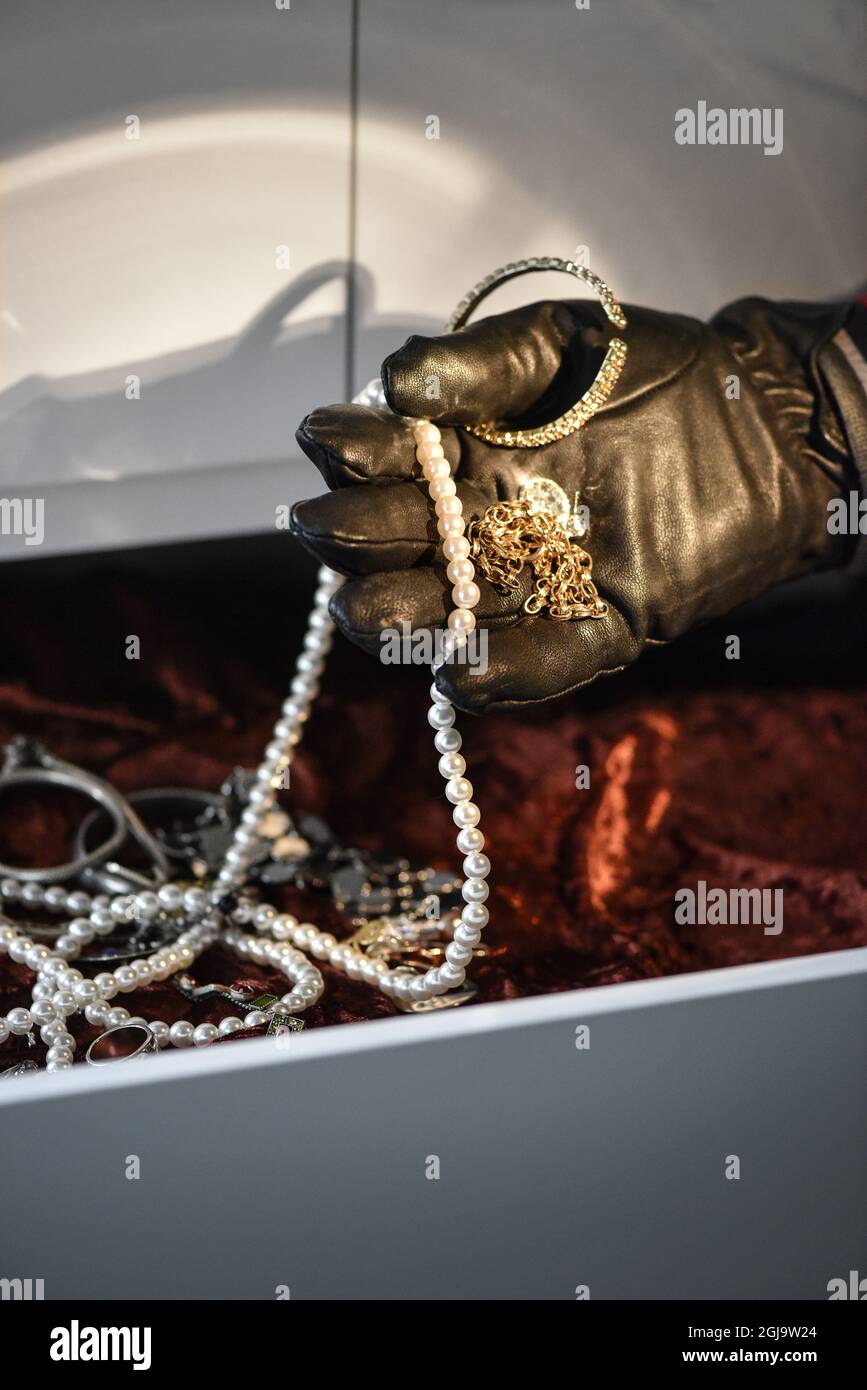 STOCKHOLM 20151103 A burglar steals jewelry from a home. Foto: Anders Wiklund / TT / Kod 10040 thief, theft, black gloves, torchlight, drawer  Stock Photo