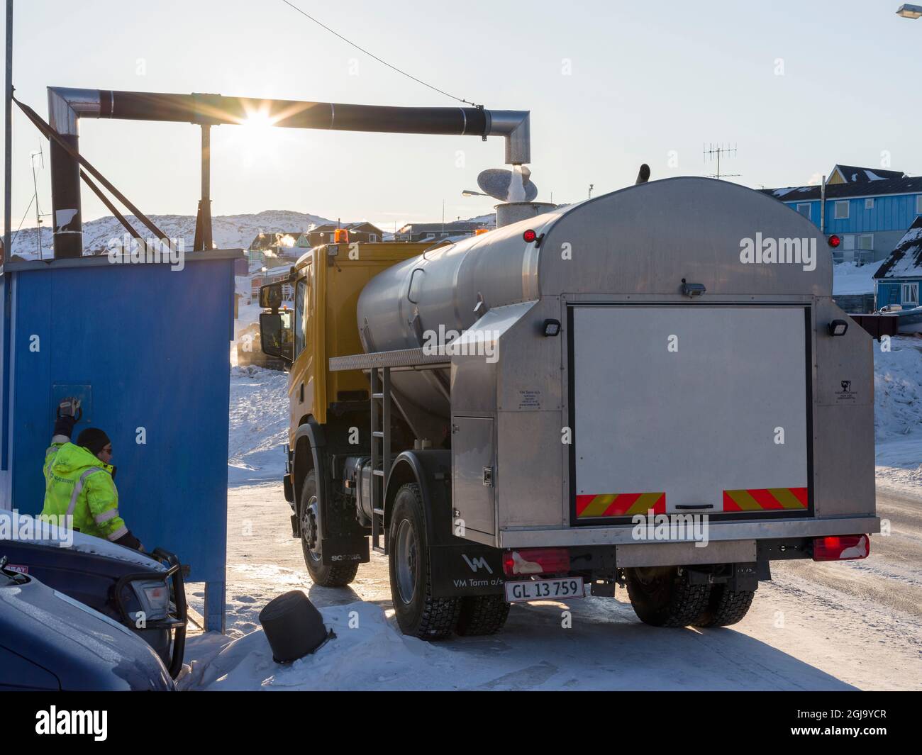 Drinking water is delivered by trucks as not all houses are connected to the water network. Winter in Ilulissat on the shore of Disko Bay. Greenland, Stock Photo