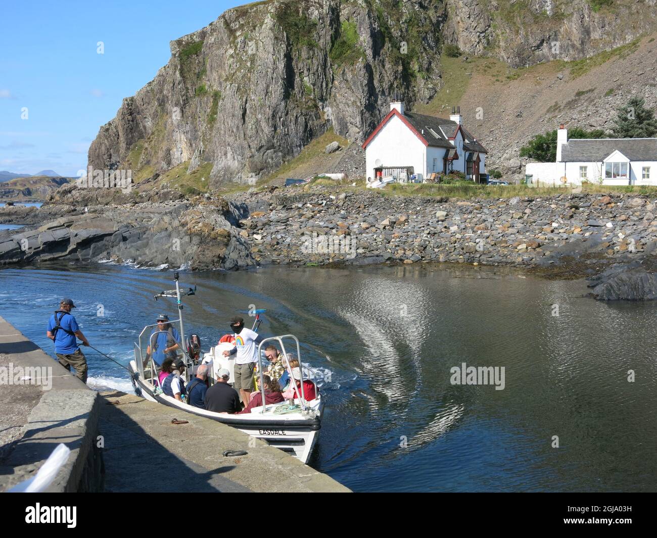 The ferry arrives on Easdale Island with passengers / tourists travelling from the neighbouring Isle of Seil  on the Scottish mainland. Stock Photo