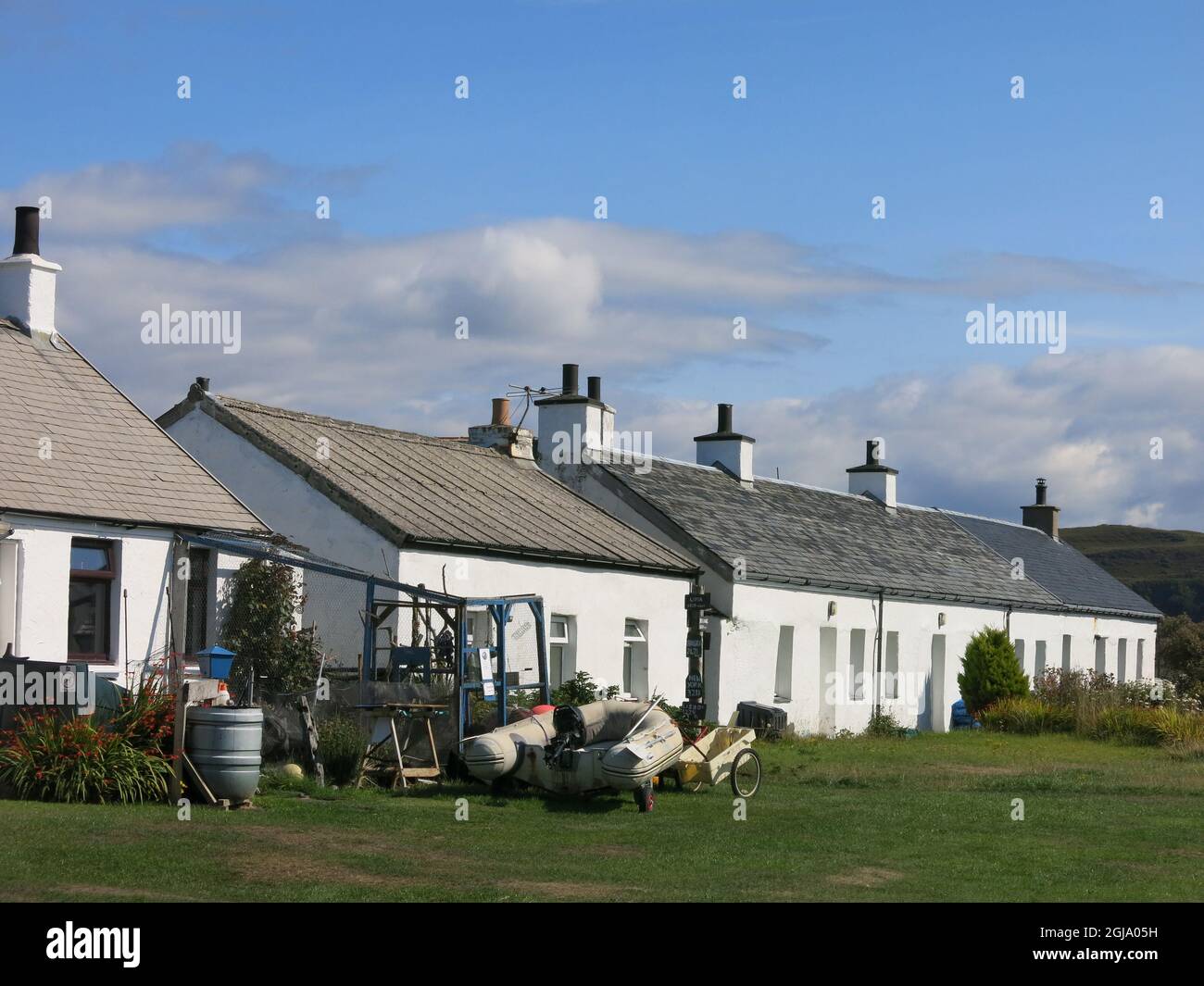 A row of traditional whitewashed stone cottages, former homes of the quarry workers on Easdale, one of the Slate Islands in the Inner Hebrides. Stock Photo