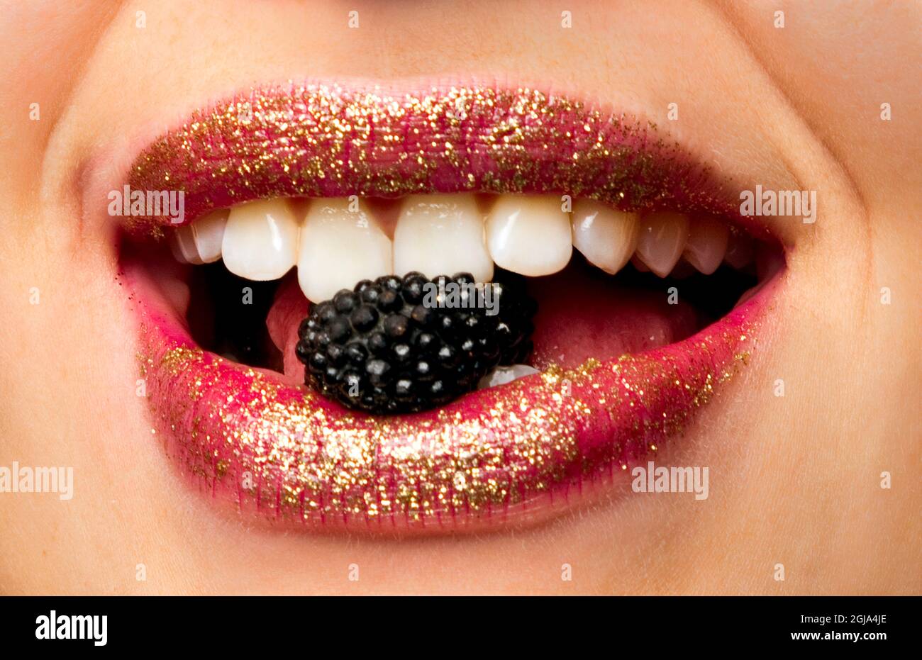 Closeup of woman's mouth and lips eating candy (MR Stock Photo Alamy