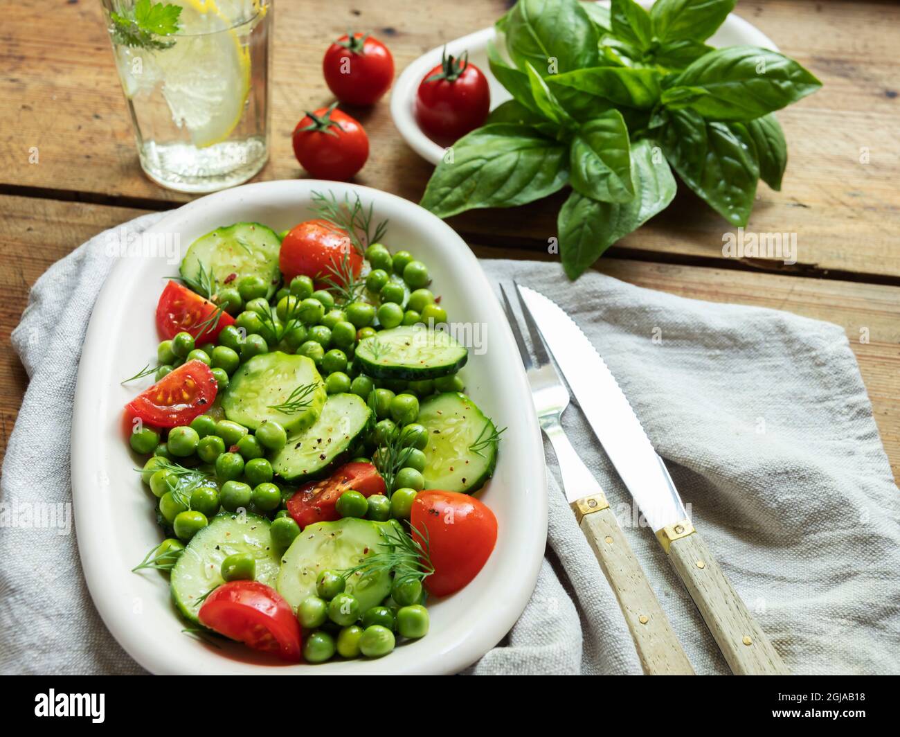 Salad. Fresh vegetable salad with tomato, cucumber, basil, green peas. Stock Photo