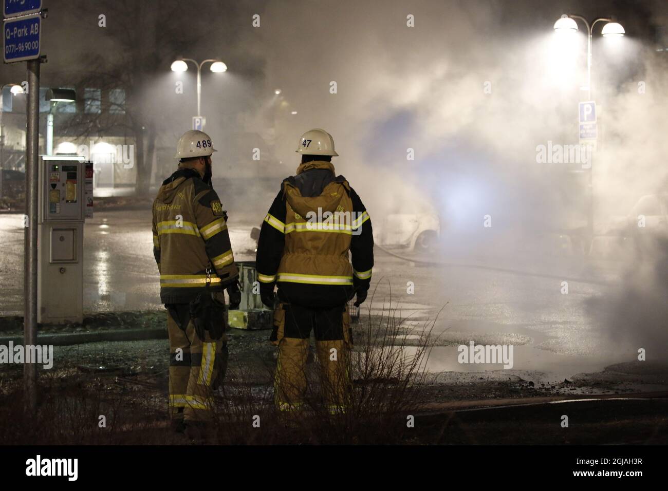 Fire fighters in the suburb Rinkeby outside Stockholm, February 20, 2017. Several cars was set in to fire after a riot in Rinkeby. The turmoil started when the police was going to arrest a man in the area. They where attacked with stones and forced use weapons. Several stores was looted and a least two persons was abused during the night. Photo: Christine Olsson / TT  Stock Photo