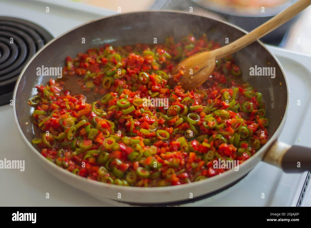 finely chopped tomatoes and peppers are sauted in a pan Stock Photo Alamy