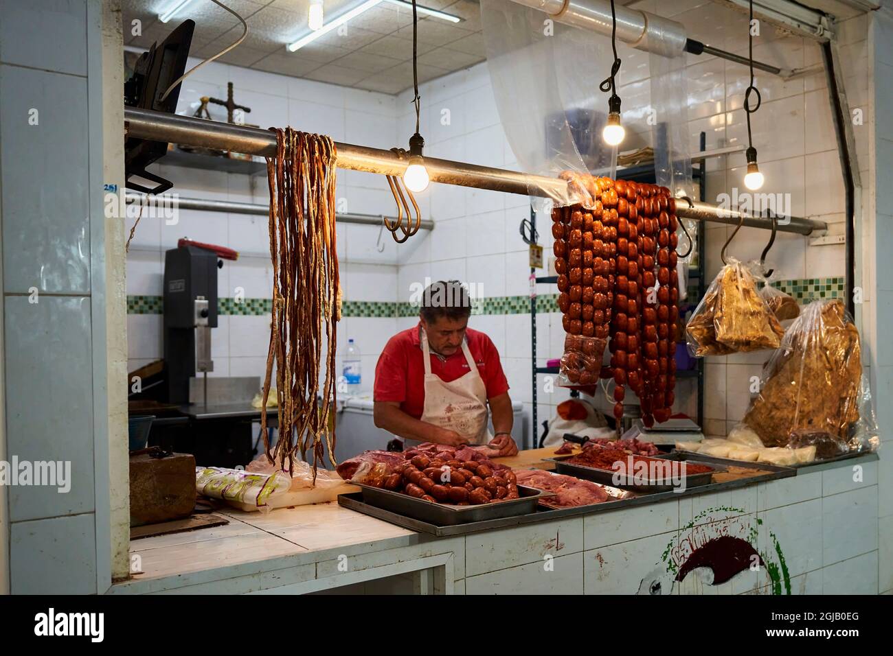 Mexico, Oaxaca. Benito Juarez Market. Several hundred stalls offer food, clothing, mezcal, handicrafts and souvenirs. A butcher fillets his product. Stock Photo