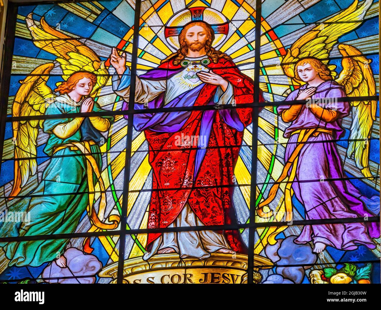 Colorful Jesus Archangels Stained glass Cathedral Puebla, Mexico. Church built in 15 to 1600's. Words say sacred heart of Jesus have mercy Stock Photo