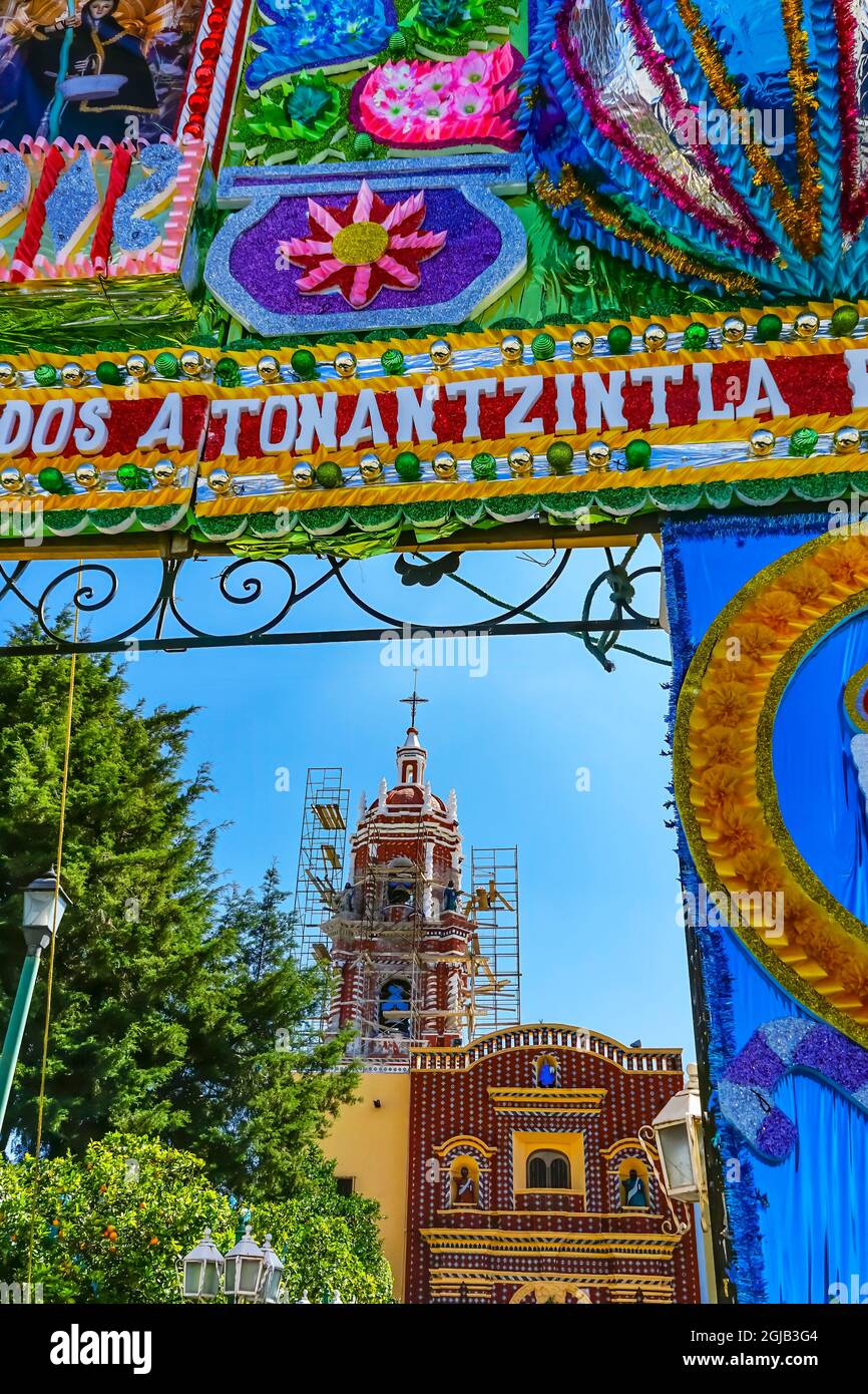 Colorful Christmas decoration on gate of Templo de Santa María Tonantzintla, Cholula, Puebla, Mexico. Words on gate say 'Happy Christmas and New Year' Stock Photo