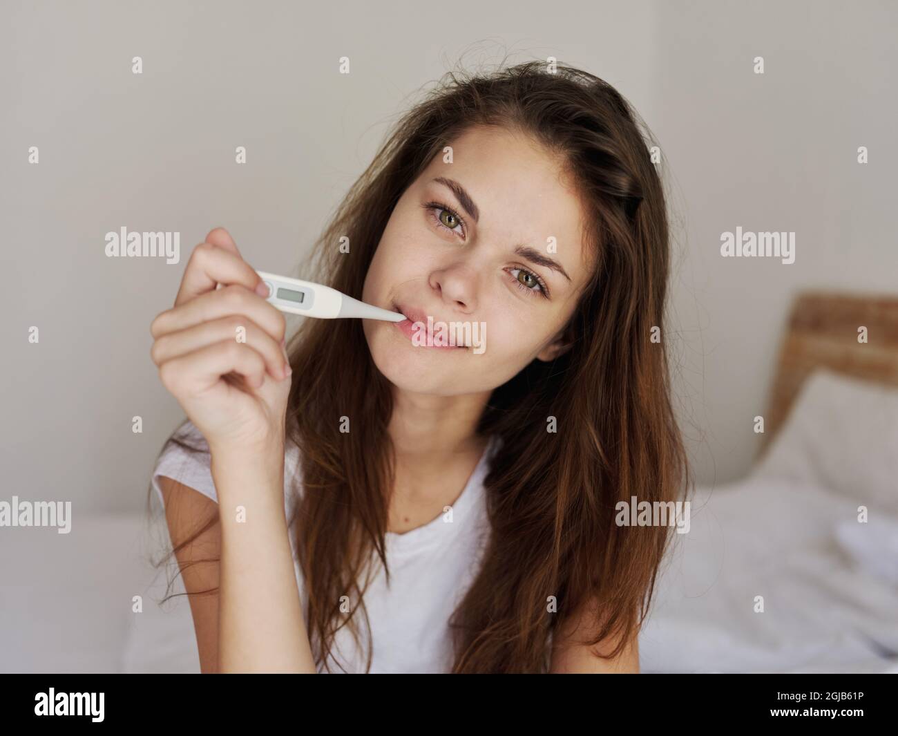 women check temperature with a thermometer in their mouth in the bedroom Stock Photo Alamy