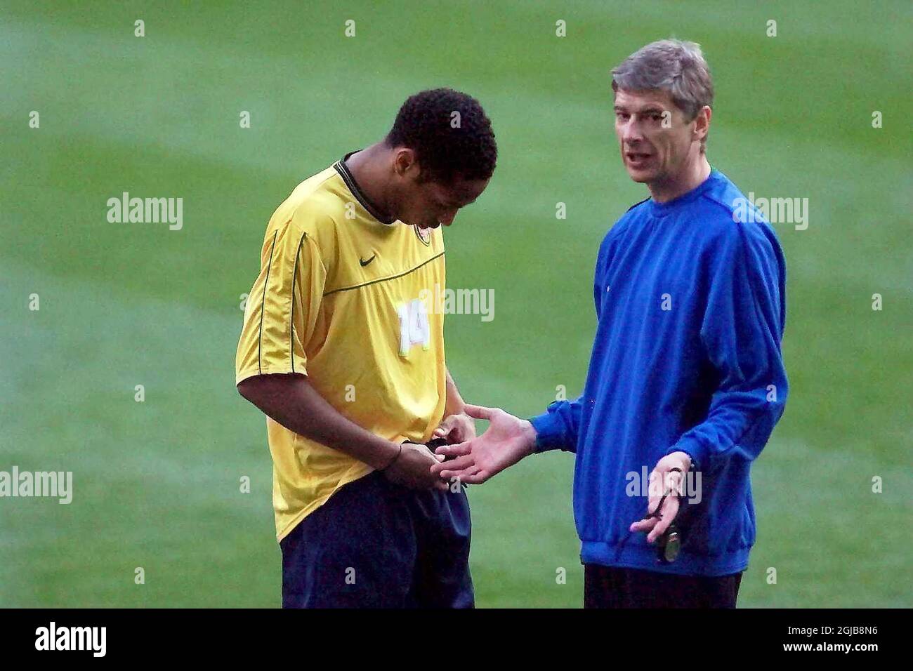 Arsenal manager Arsene Wenger (r) talks tactics with Thierry Henry (l