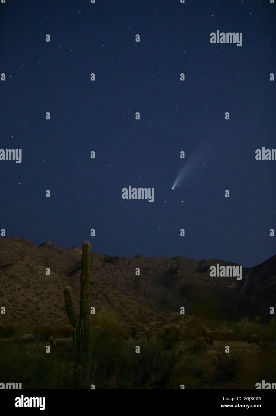 USA, Arizona, Buckeye. Comet Neowise spews trail over White Tank Mountains and desert. Stock Photo