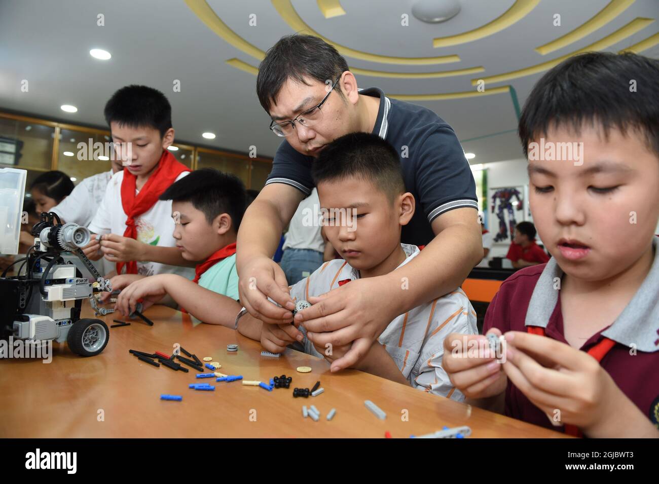Hefei, China's Anhui Province. 8th Sep, 2021. Yang Sen instructs his students at the robot club at Heping Primary School in Hefei City, east China's Anhui Province, Sept. 8, 2021. Yang Sen, a computer teacher from Heping Primary School, has interest in graphical language applied to robots in his spare time. After class, he organizes a robot club instructing his students to explore the use of multiple sensors and various scientific principles. Credit: Zhou Mu/Xinhua/Alamy Live News Stock Photo