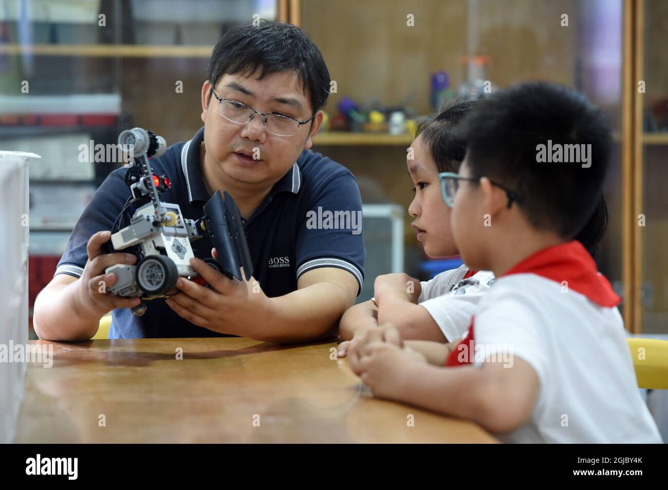 Hefei, China's Anhui Province. 8th Sep, 2021. Yang Sen instructs his students at the robot club at Heping Primary School in Hefei City, east China's Anhui Province, Sept. 8, 2021. Yang Sen, a computer teacher from Heping Primary School, has interest in graphical language applied to robots in his spare time. After class, he organizes a robot club instructing his students to explore the use of multiple sensors and various scientific principles. Credit: Zhou Mu/Xinhua/Alamy Live News Stock Photo