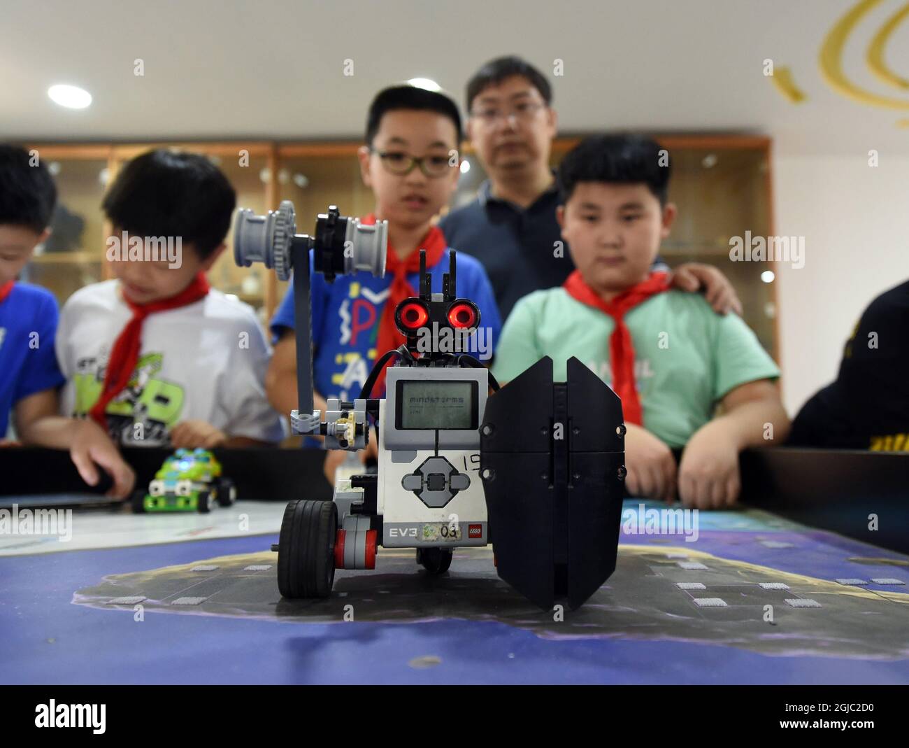 Hefei, China's Anhui Province. 8th Sep, 2021. Yang Sen (R2) instructs his students at the robot club at Heping Primary School in Hefei City, east China's Anhui Province, Sept. 8, 2021. Yang Sen, a computer teacher from Heping Primary School, has interest in graphical language applied to robots in his spare time. After class, he organizes a robot club instructing his students to explore the use of multiple sensors and various scientific principles. Credit: Zhou Mu/Xinhua/Alamy Live News Stock Photo
