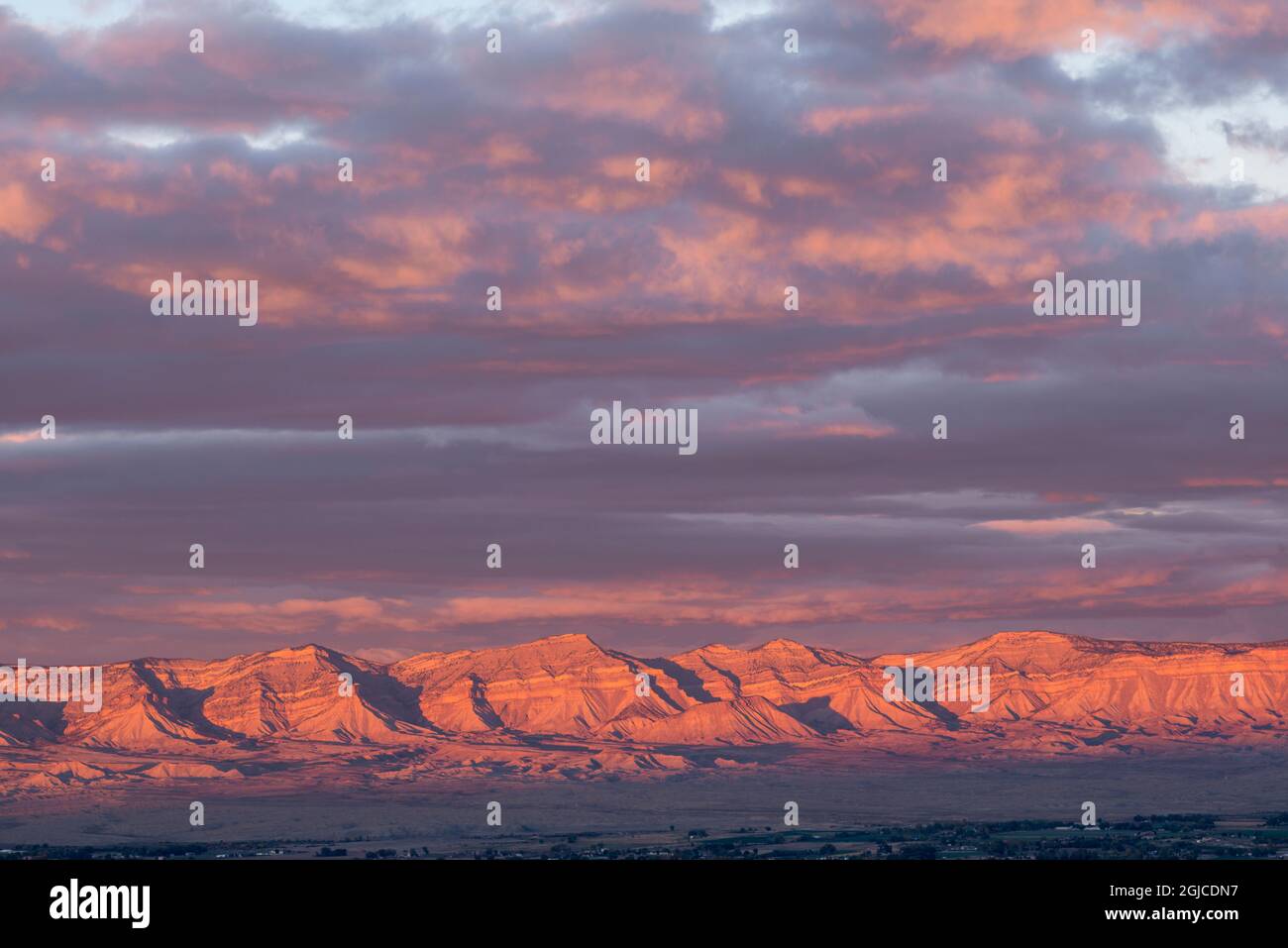 USA, Colorado, Sunset sky over Book Cliffs and town of Fruita, view north from Book Cliffs View in Colorado National Monument. Stock Photo