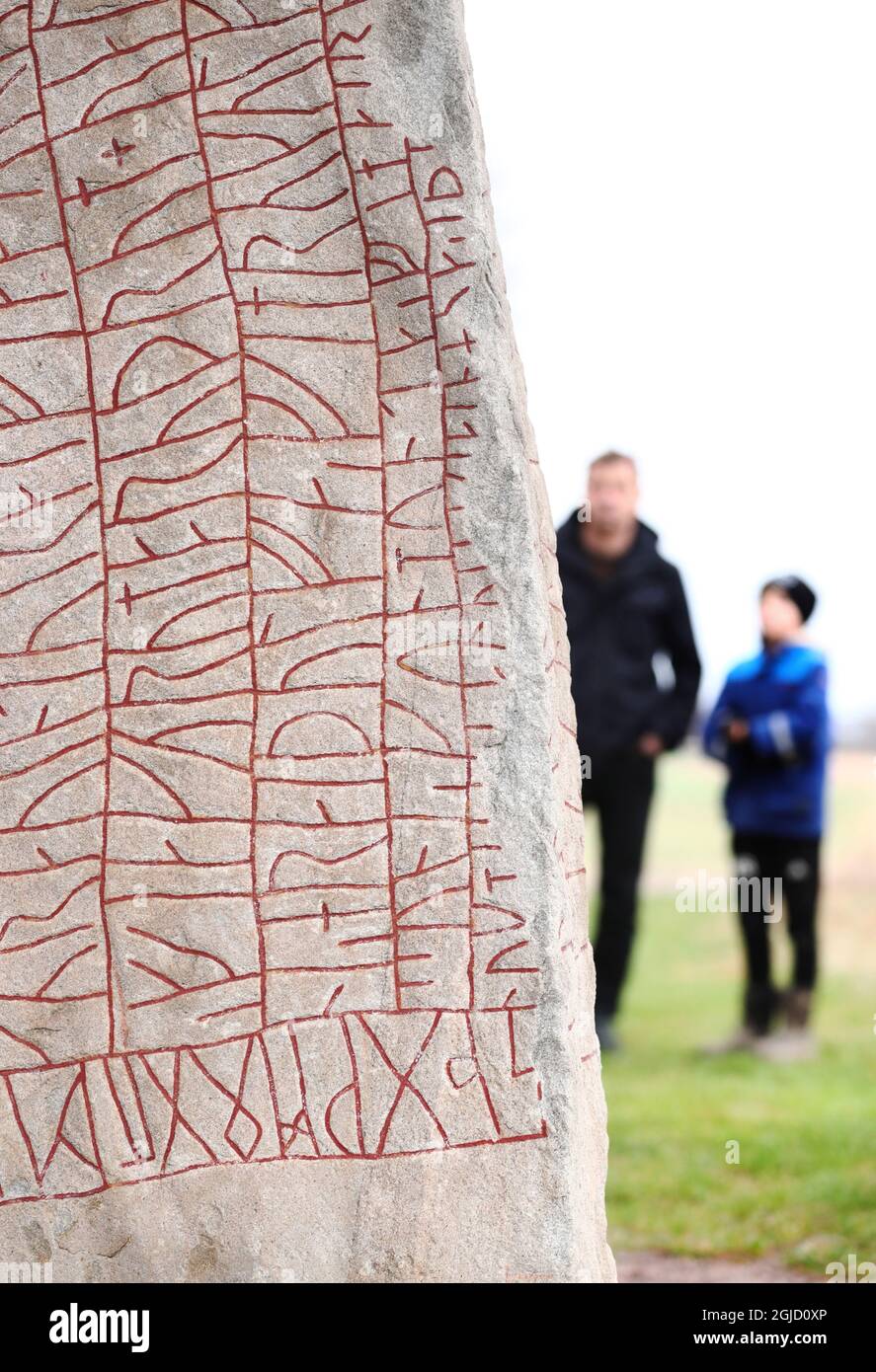 A father and a son look at the Viking-era Rok runestone near the Lake ...