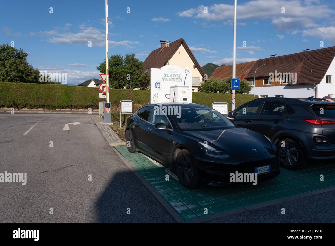 Kapfenberg, Austria - July 9, 2021: A static shot of a solid black Tesla Model 3 dual motor  charging at the Lidl supermarket DC charging station Stock Photo