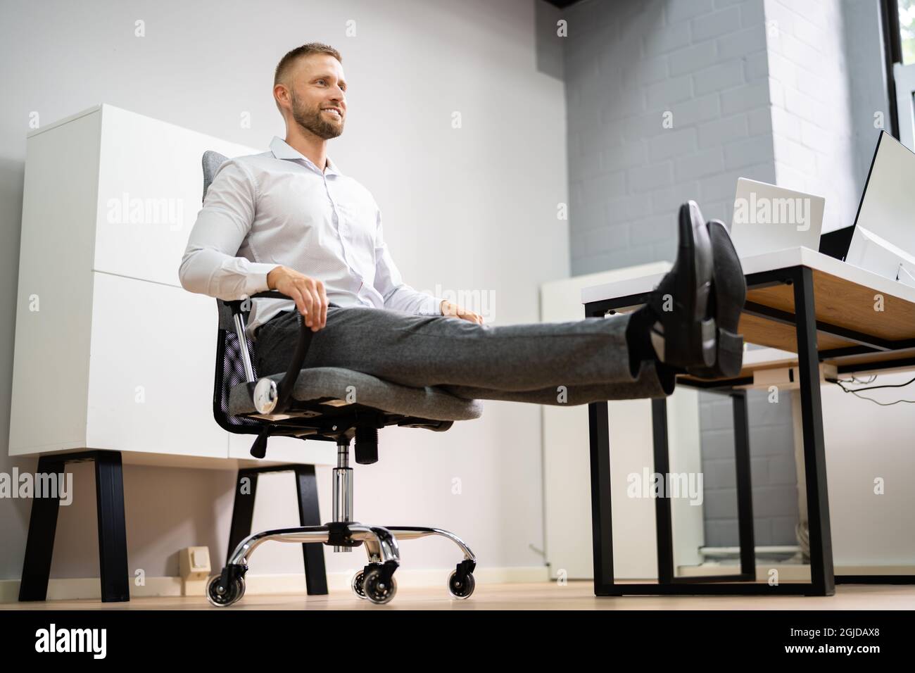 Yoga Workout In Office Behind Business Computer. Gymnastics And Leg ...