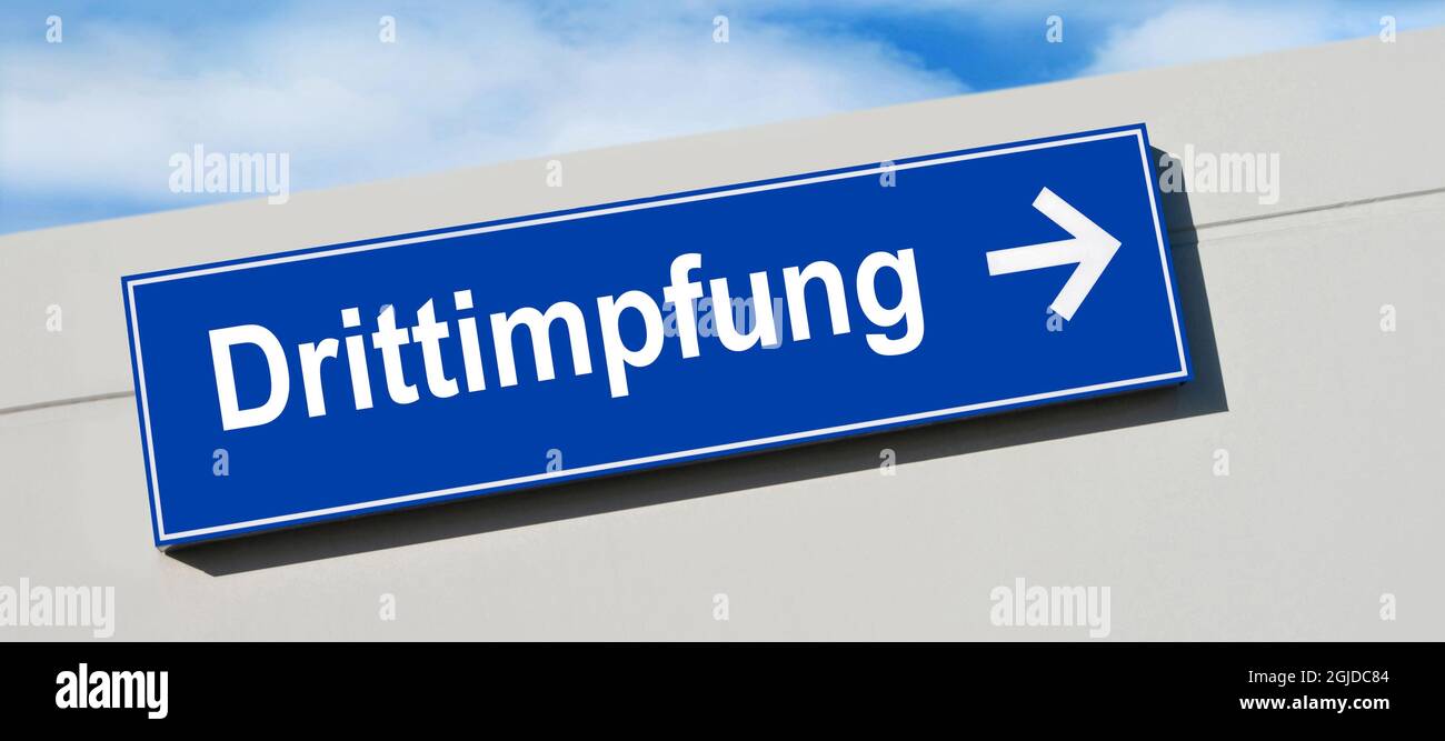 German third corona vaccination and blue traffic sign Stock Photo