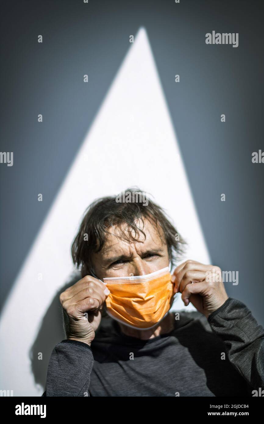 A man putting on a face mask. Photo: Claudio Bresciani / TT / code ...
