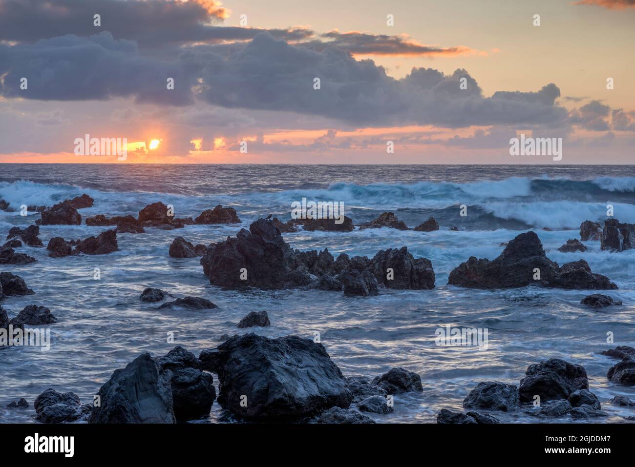 USA, Hawaii, Big Island of Hawaii. Laupahoehoe Point Beach Park, Sunrise over waves and rough volcanic rock. Stock Photo
