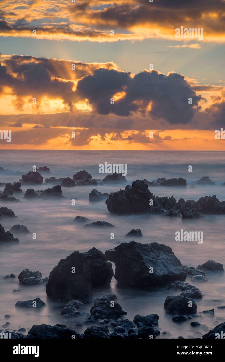 USA, Hawaii, Big Island of Hawaii. Laupahoehoe Point Beach Park, Sunrise over waves and rough volcanic rock. Stock Photo