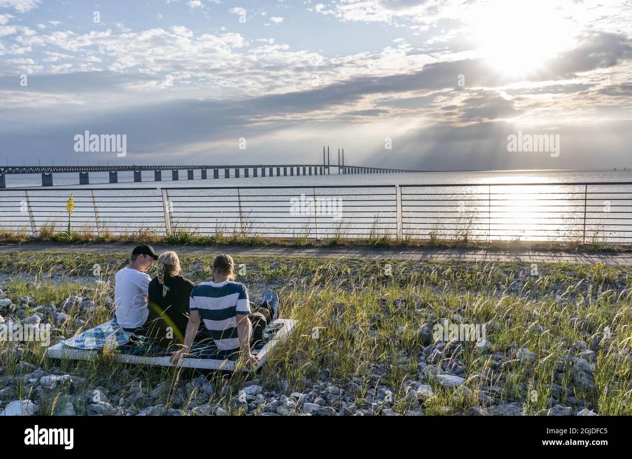 People enjoy the sun set and the view of the Oresund Bridge from a view point outside Malmo, Sweden on the July 01, 2020. Today the bridge, which connects Sweden and Denmark, celebrates it’s 20th birthday. Photo: Johan Nilsson / TT / Kod 50090  Stock Photo