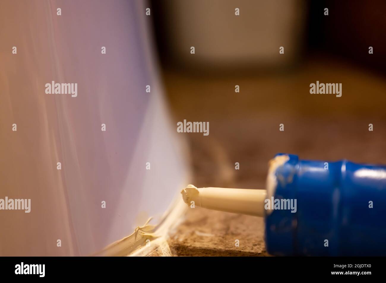 Selective focus on silicone caulking ready to be applied around the