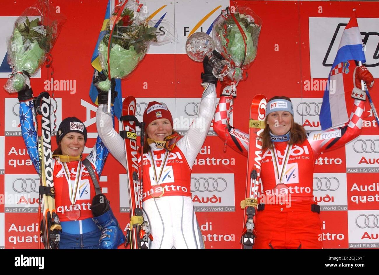 Sweden's Anja Paerson (c) raises the glass trophy she was awarded for the overall victory in the women's giant slalom. Italy's Karen Putzer (l) finished second and Croatia's Janica Kostelic (r) third  Stock Photo