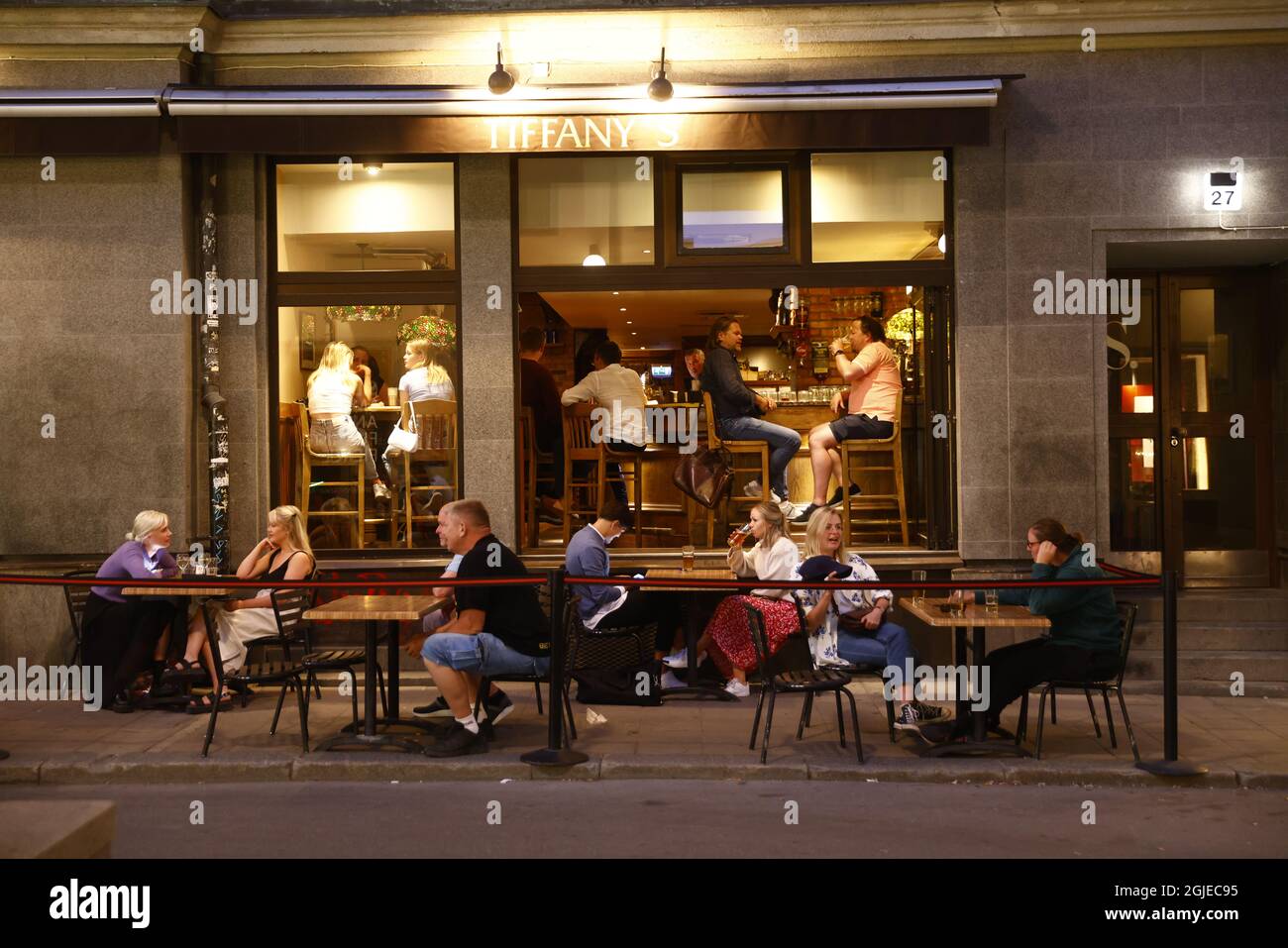 People sit at the tables outside a restaurant in Stockholm, Sweden