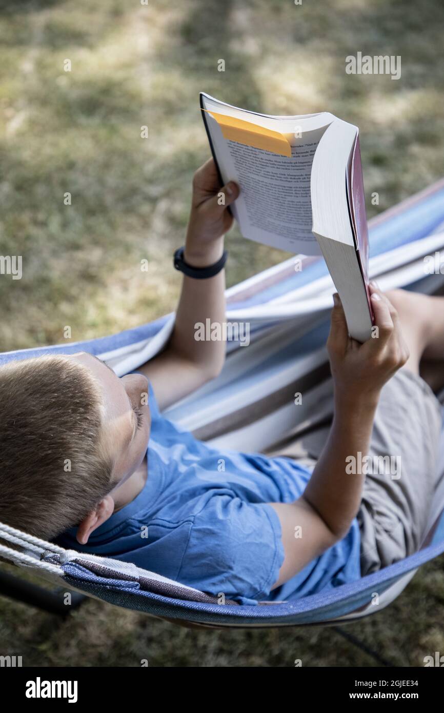 Child reading in a hammock hi-res stock photography and images - Alamy
