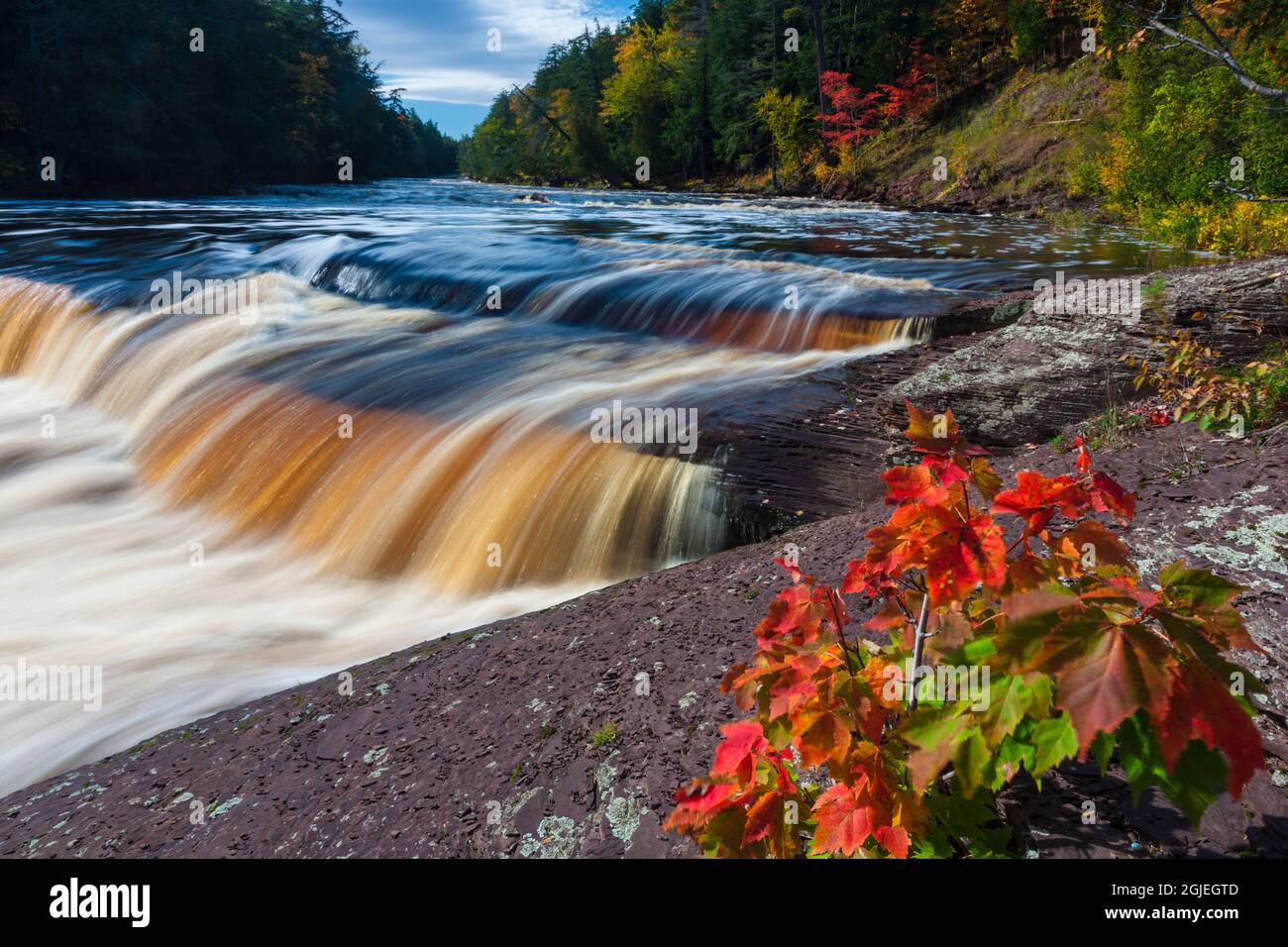 USA, Michigan. Fall colors at Presque Isle River waterfall on the south ...