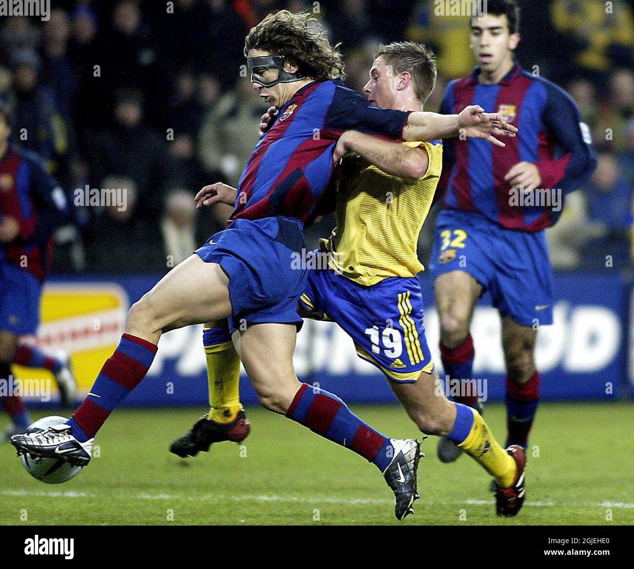 Barcelona's Carles Puyol (l) is challenged by Brondby's Karsten Johansen (r) Stock Photo