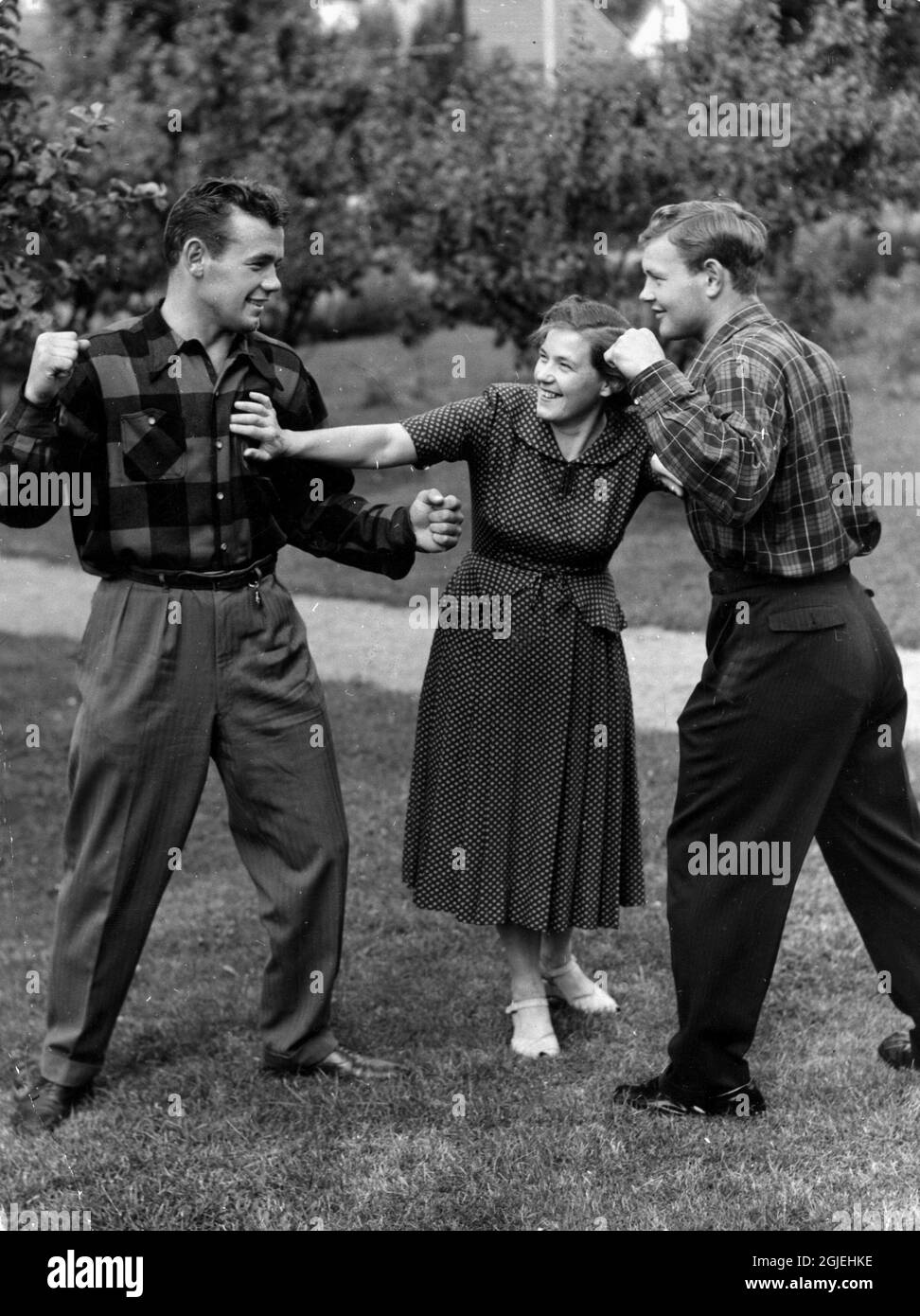 Ebba, mother of Swedish world heavyweight boxing champion Ingemar Johansson (L), separates Ingemar and his brother Henry during a 'fight' in the Johansson family's garden in Grimmered in Gothenburg in 1952. Stock Photo