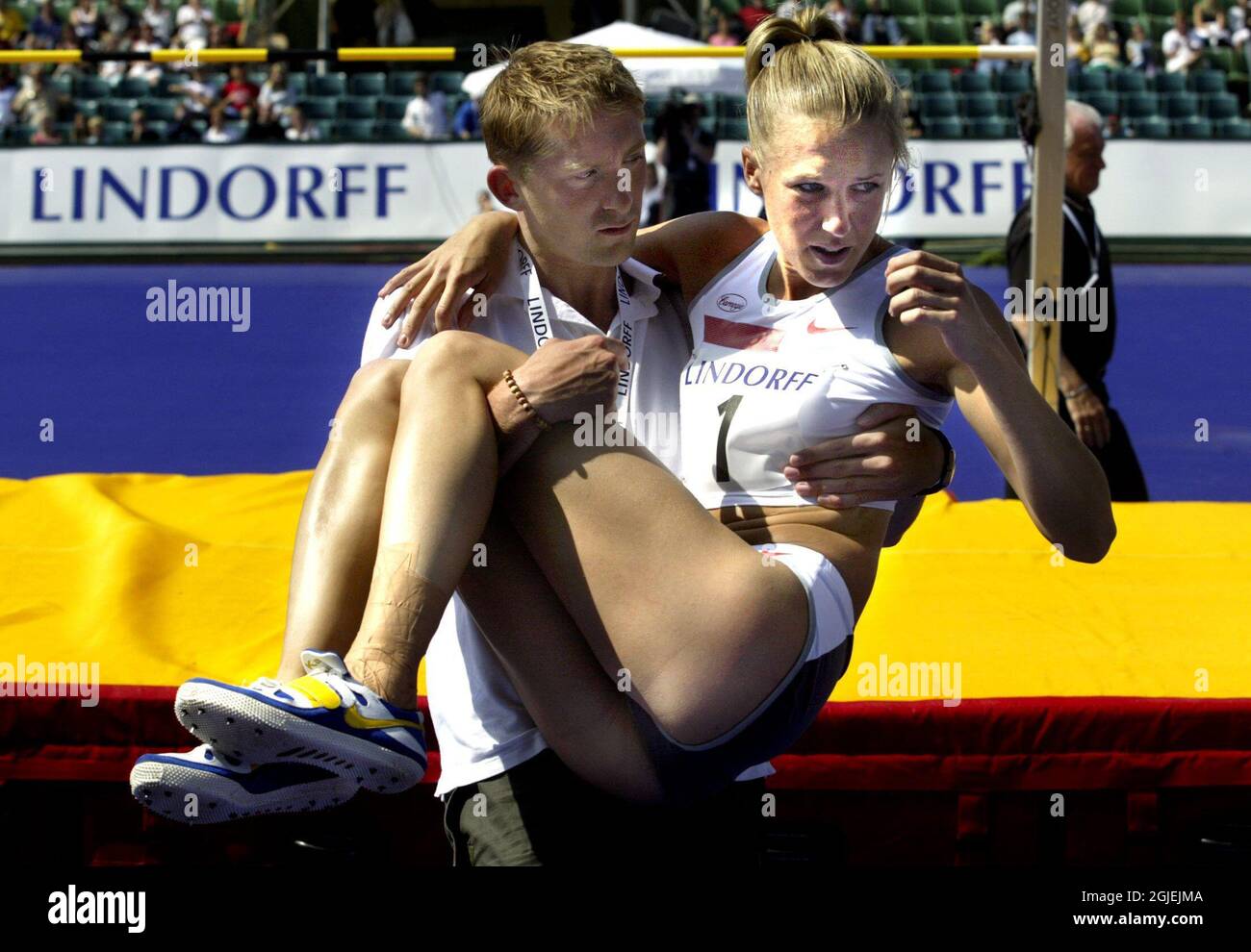 Swedish high jumper Kajsa Bergqvist is carried from the arena by her trainer Yannick Tregaro after her Achilles' tendon snapped. Bergqvist, who was a gold medal candidate for the Olympic Games will now miss the event. Stock Photo