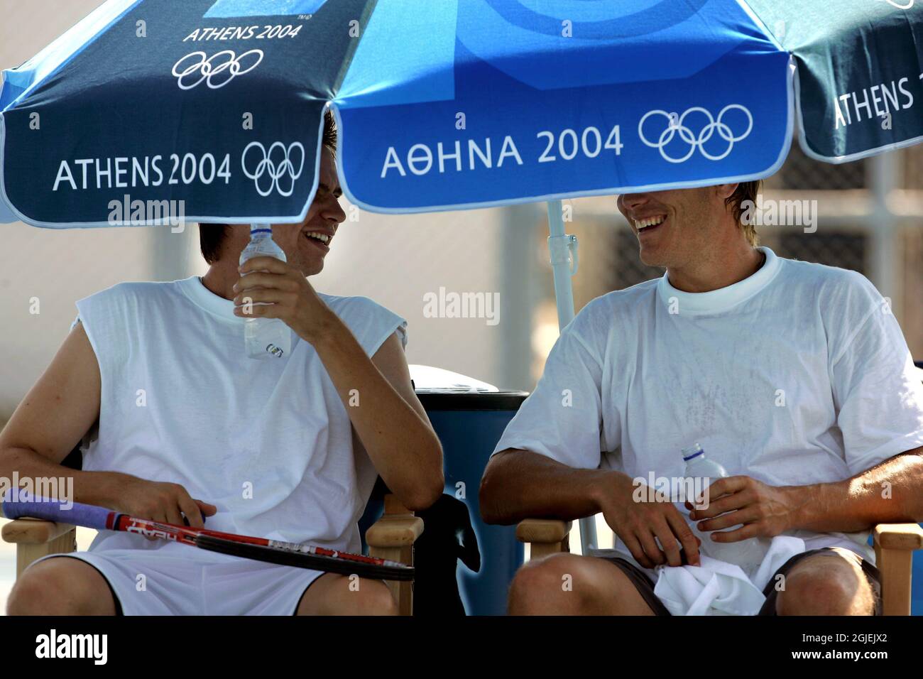 Sweden's Robin Soderling and Thomas Enqvist share a joke and the shade under an umbrella Stock Photo