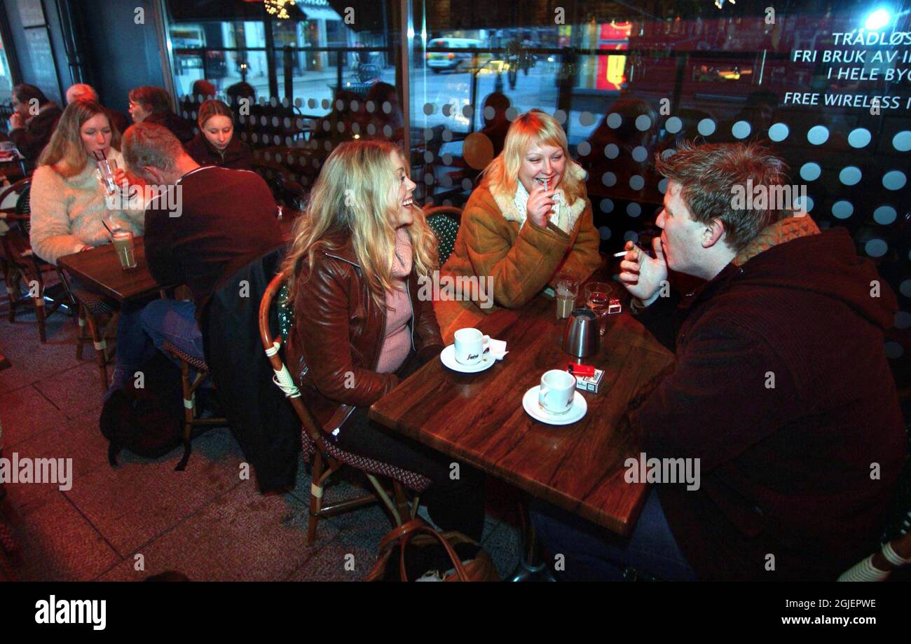 Guests smoking at the restaurant Mona Lisa in Oslo, Norway. It is one year since smoking was banned at restaurants and pubs in Oslo, Norway. Since then restaurant owners are avoiding the ban by building tents and other facilities on the streets and back yards outside the restaurant for smoking guests. The facilities are often equipped with radiators to keep the guest warn during the cold Norwegian winter. Stock Photo