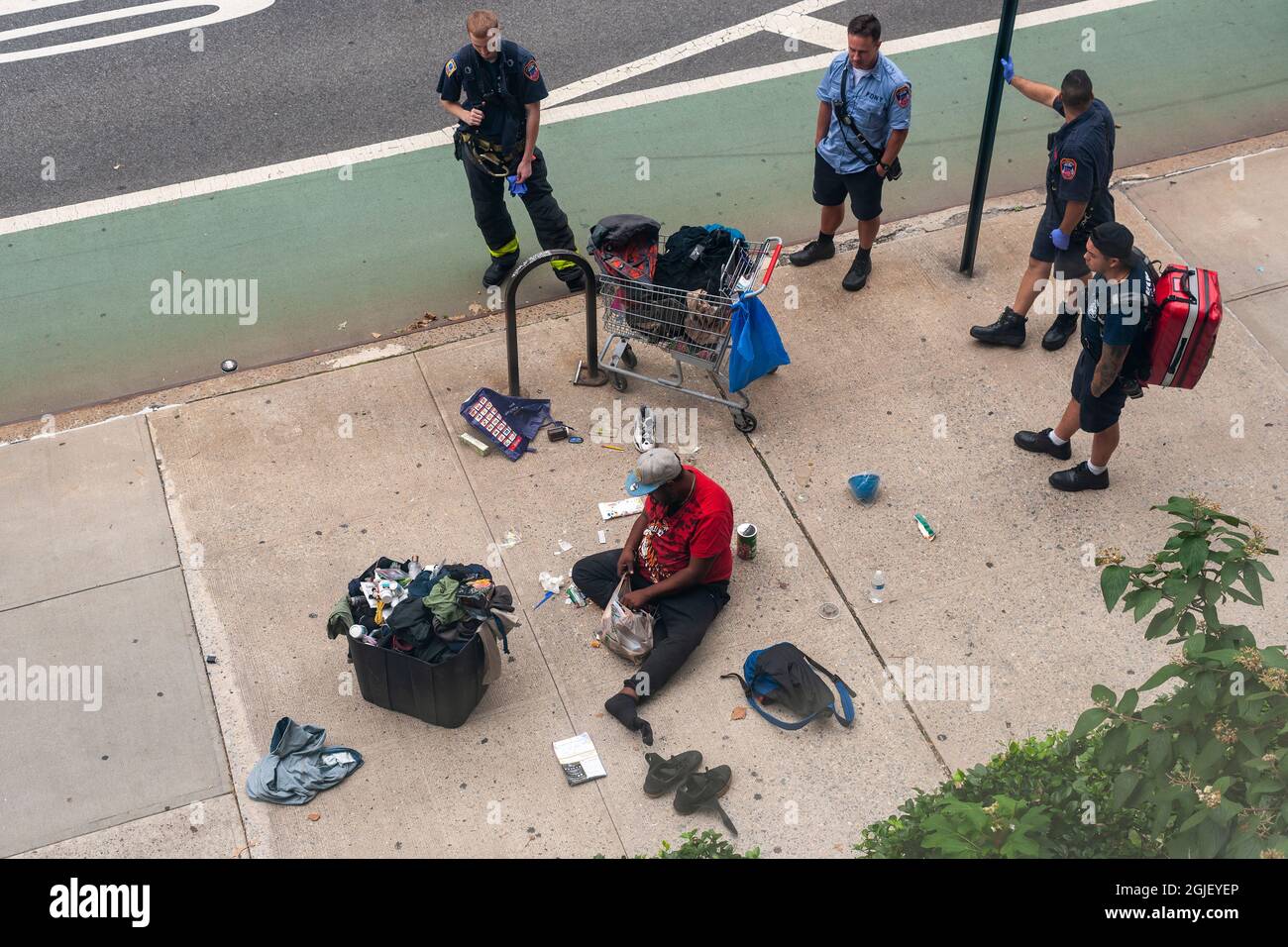 Members of the FDNY wait as a homeless individual collects his possessions after sleeping in the middle of the sidewalk in Chelsea in New York on Sunday, August 29, 2021. (© Richard B. Levine) Stock Photo