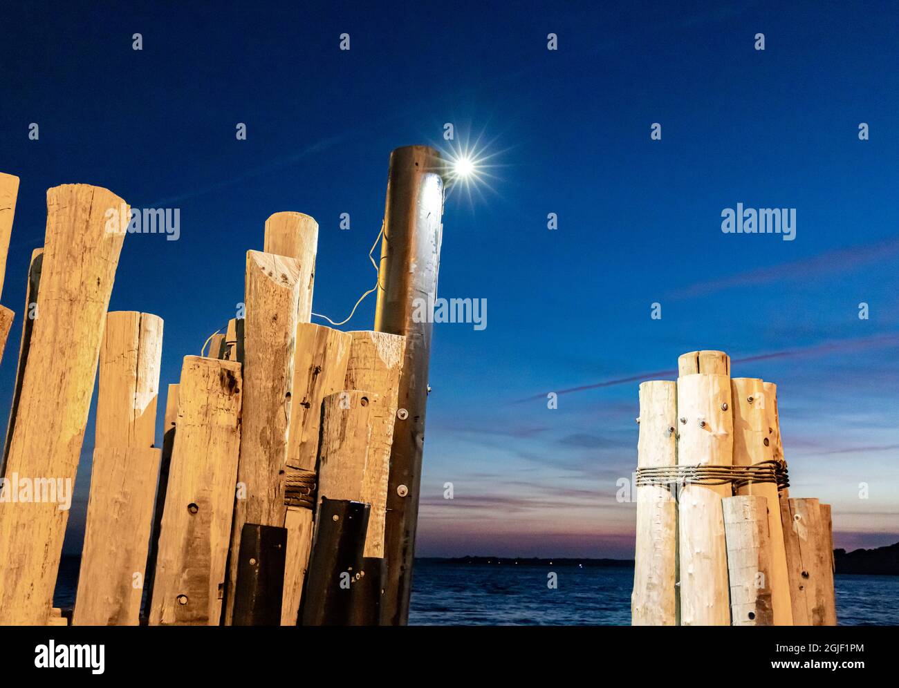 Wooden nautical pilings at night Stock Photo