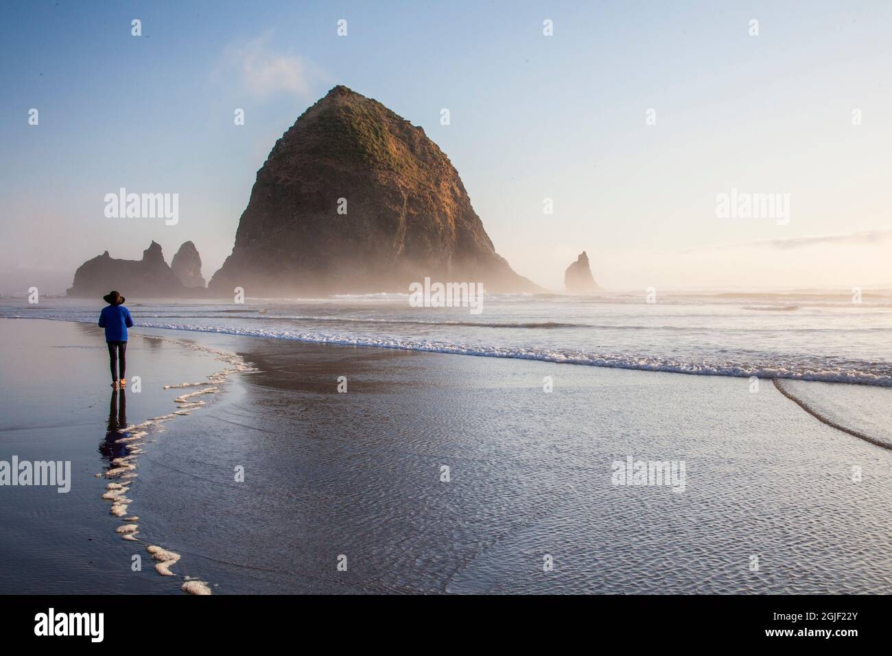 USA, Oregon Cannon Beach with Haystack rock and visitor looking out at