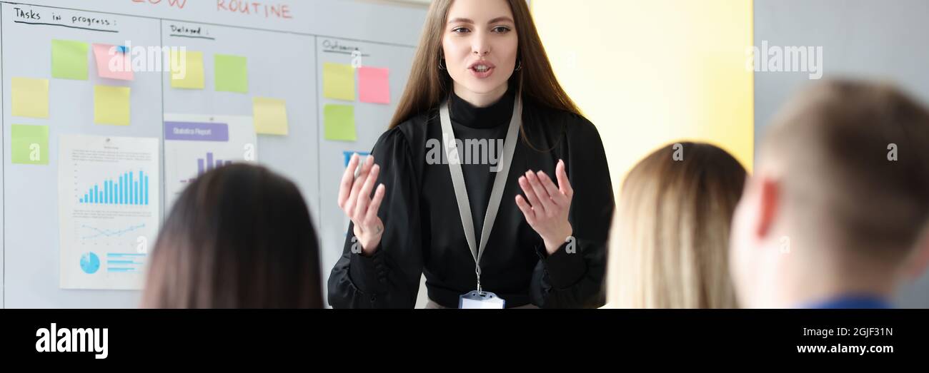 Successful businesswoman standing at blackboard at conference Stock Photo