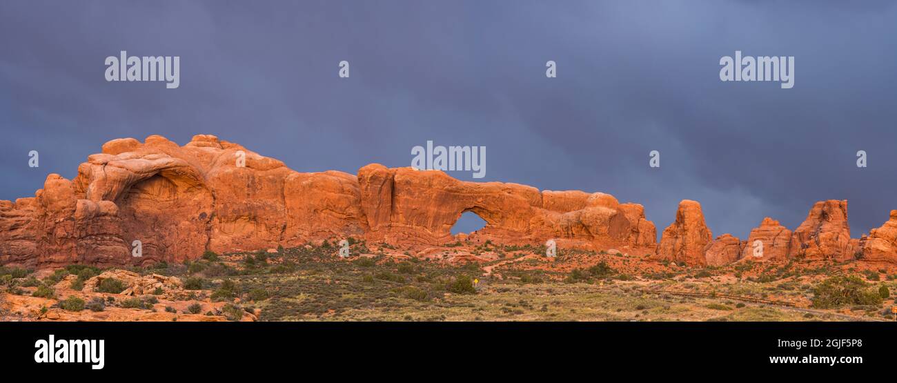 Utah, Arches National Park. A panorama view of the windows section of the park. Light breaks through clouds during an afternoon storm, illuminating th Stock Photo