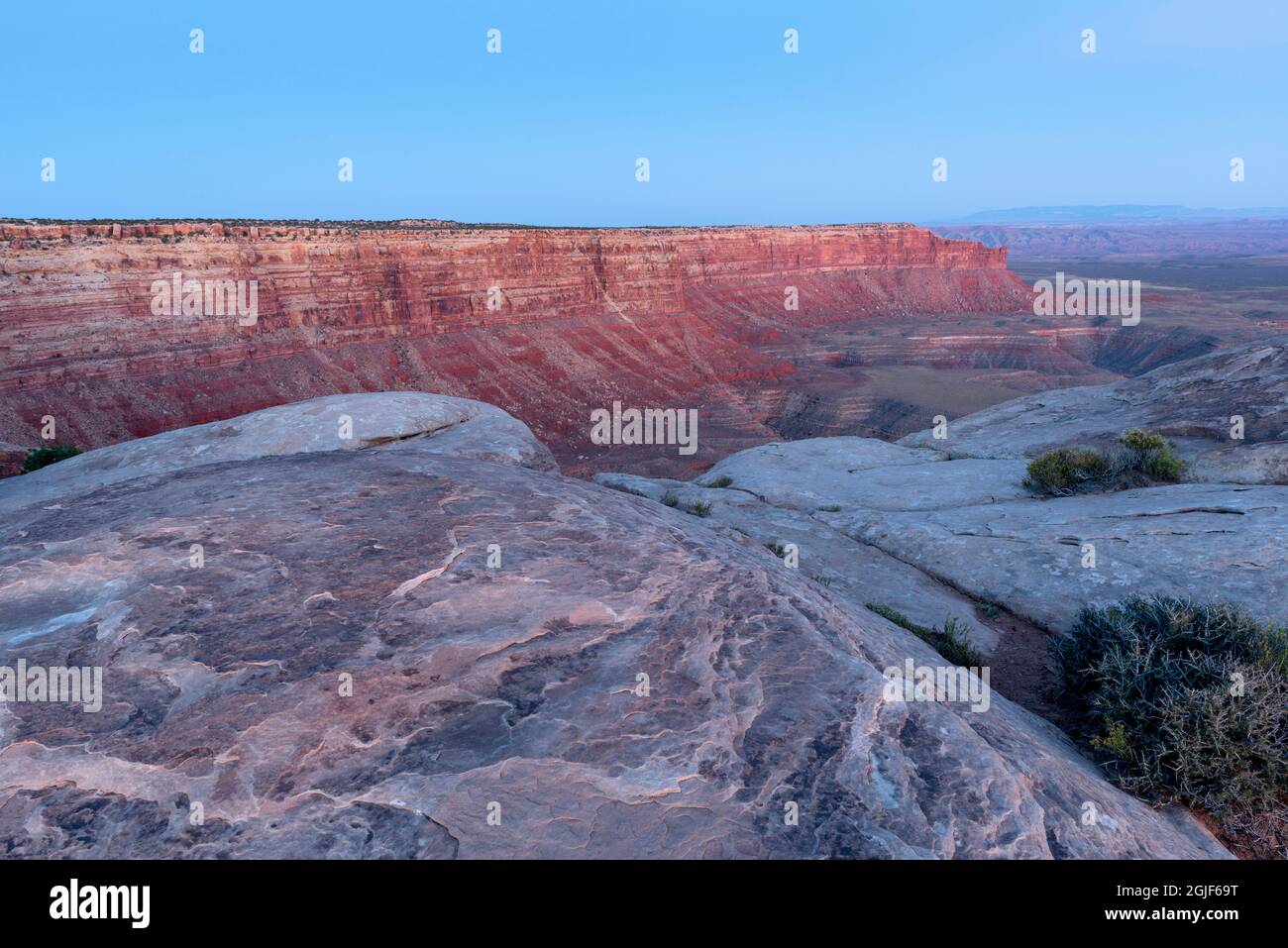 USA, Utah, Glen Canyon National Recreation Area, Cedar mesa sandstone at Muley Point and view east at dusk with nearby butte and distant Raplee Ridge. Stock Photo