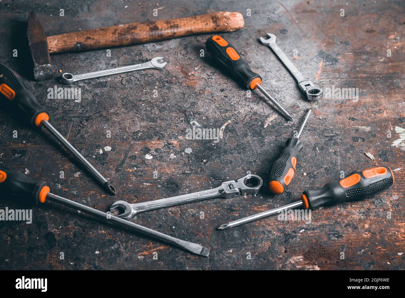 Screwdrivers, wrenches and hammer on a wooden workbench. Top view on working tools with space for text. Construction tools on work wooden table. Stock Photo